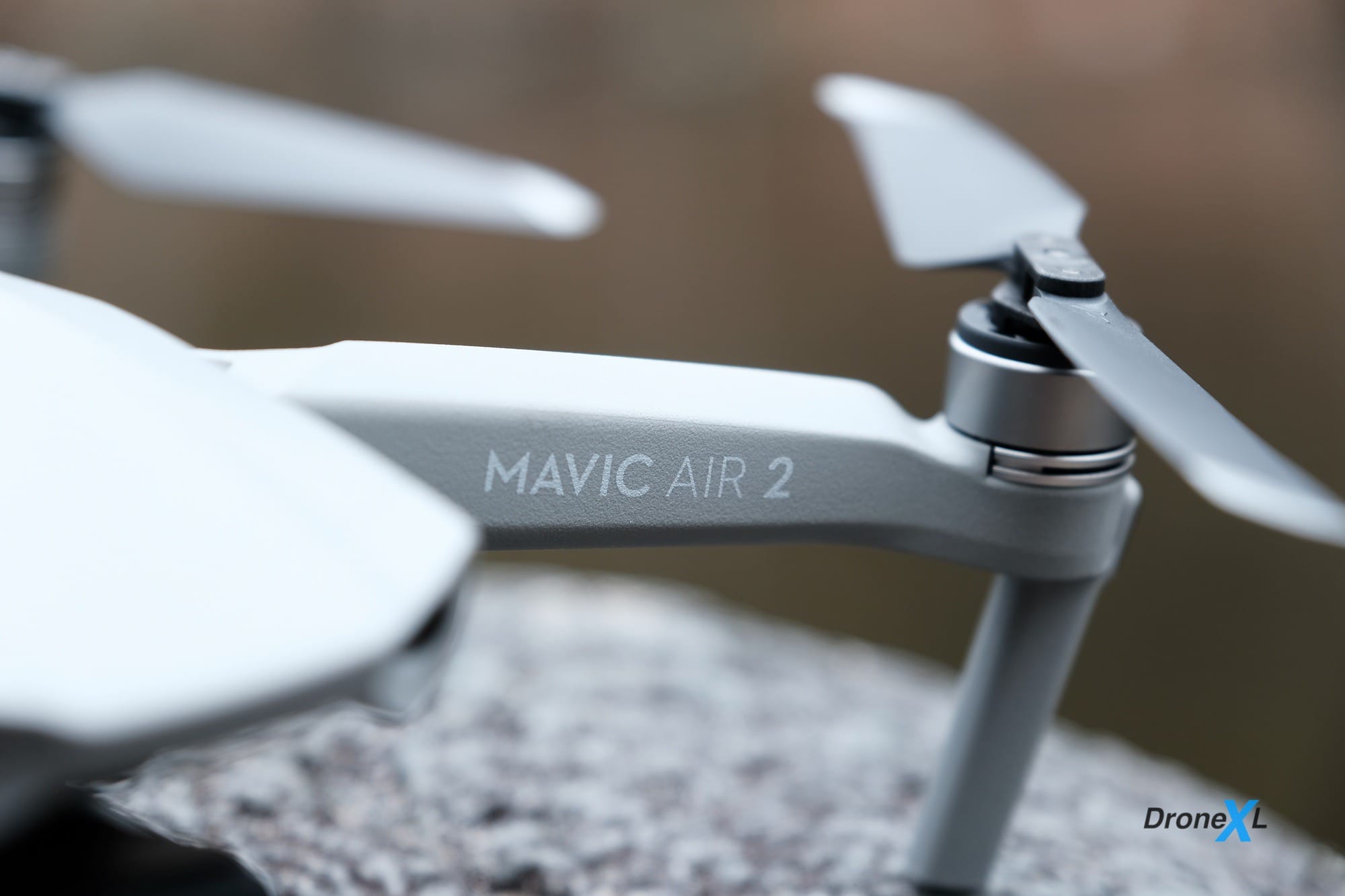 Close-up of a DJI Mavic Air 2 on gravel with its model name visible.