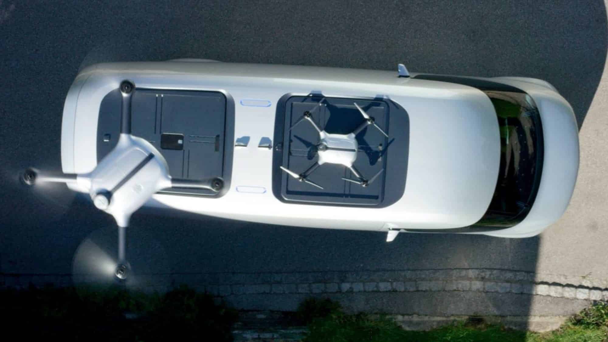 Top-down view of a delivery drone lifting from a launch hatch on a white van roof.
