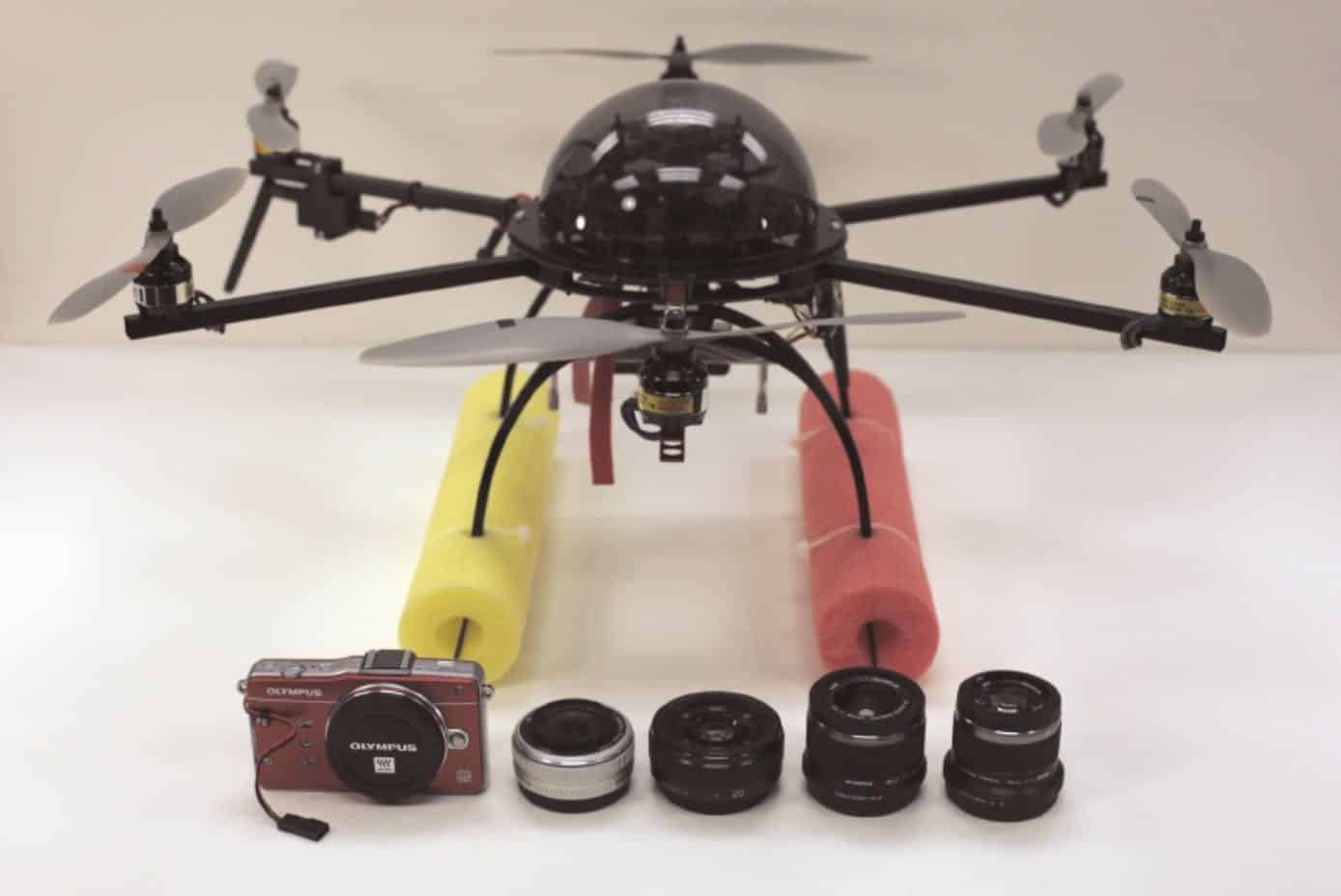 APH-22 hexacopter drone displayed with an Olympus camera and five interchangeable lenses.