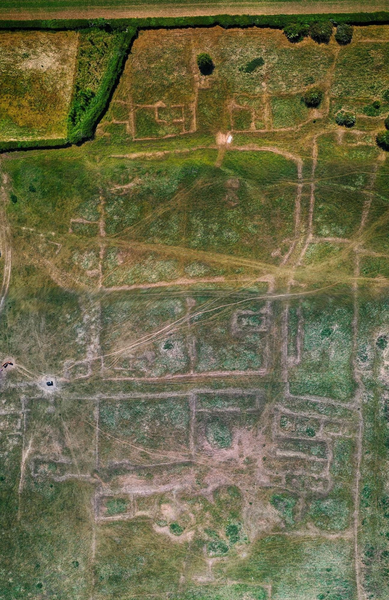 Composite aerial drone photo of Gainsthorpe medieval village showing streets and grassy earthworks.