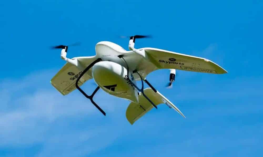 Skyports Wingcopter delivery aircraft climbing against a clear blue sky.
