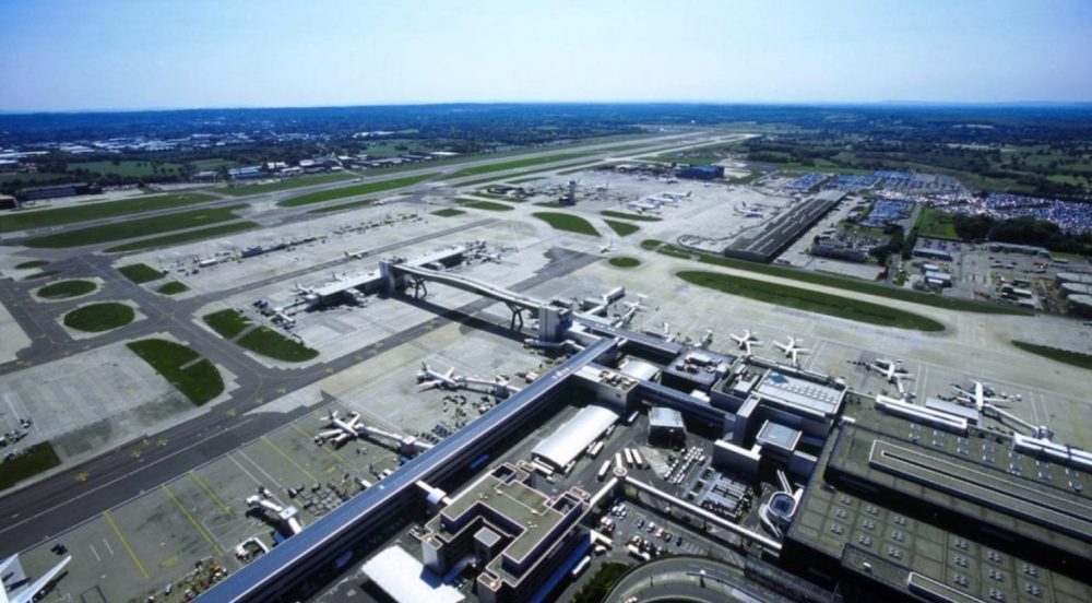 Aerial view of an airport terminal with parked airliners, taxiways and runways.