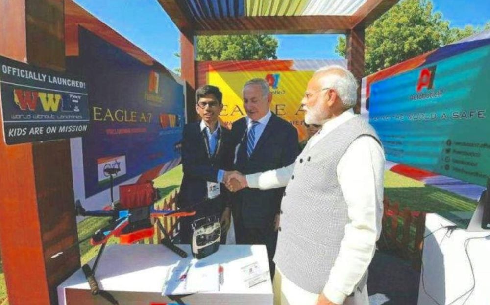 Teen inventor shakes hands with Benjamin Netanyahu beside Narendra Modi at an Eagle A7 drone booth.
