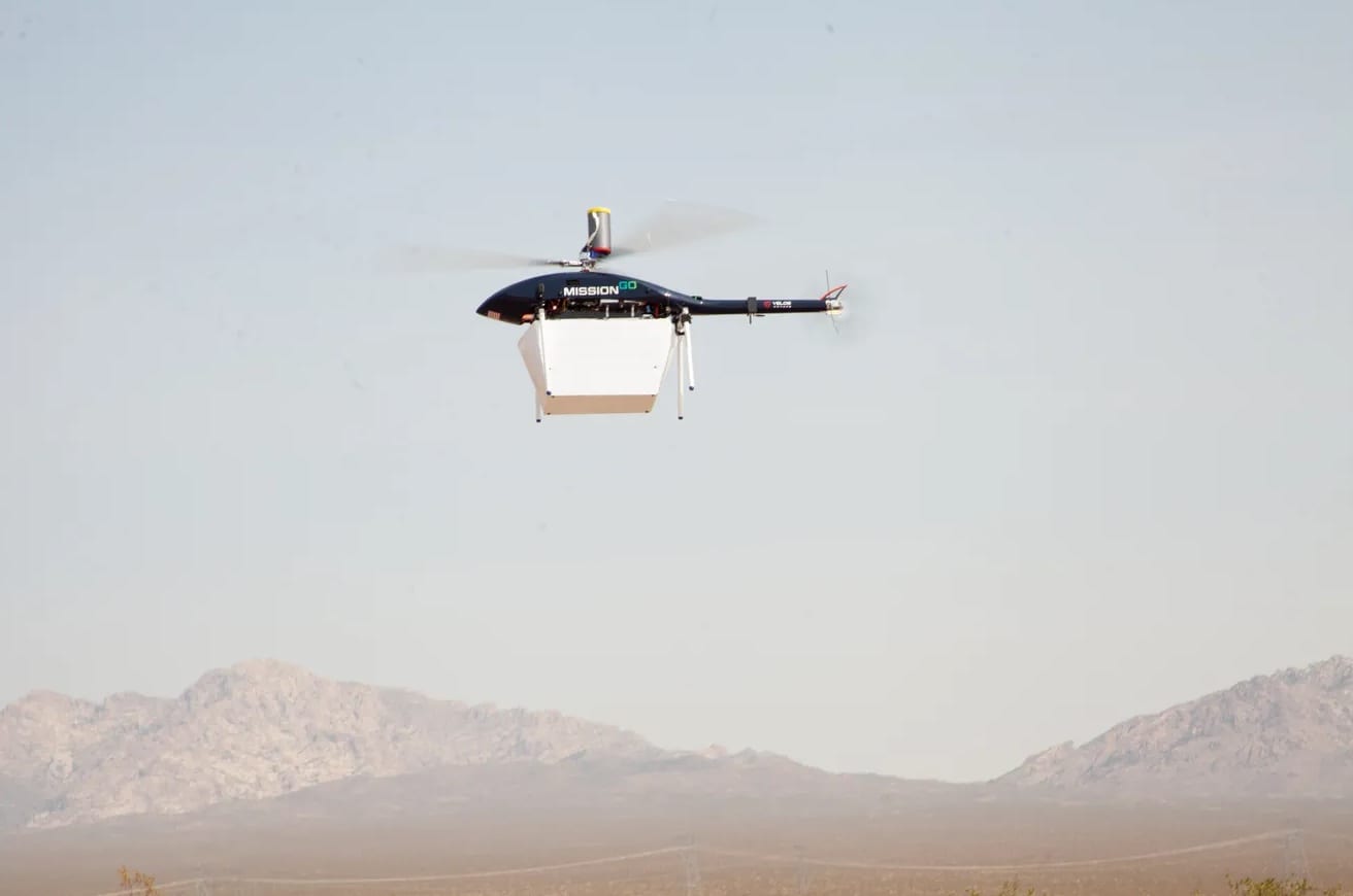 Unmanned helicopter carrying an organ transport container over the Nevada desert.