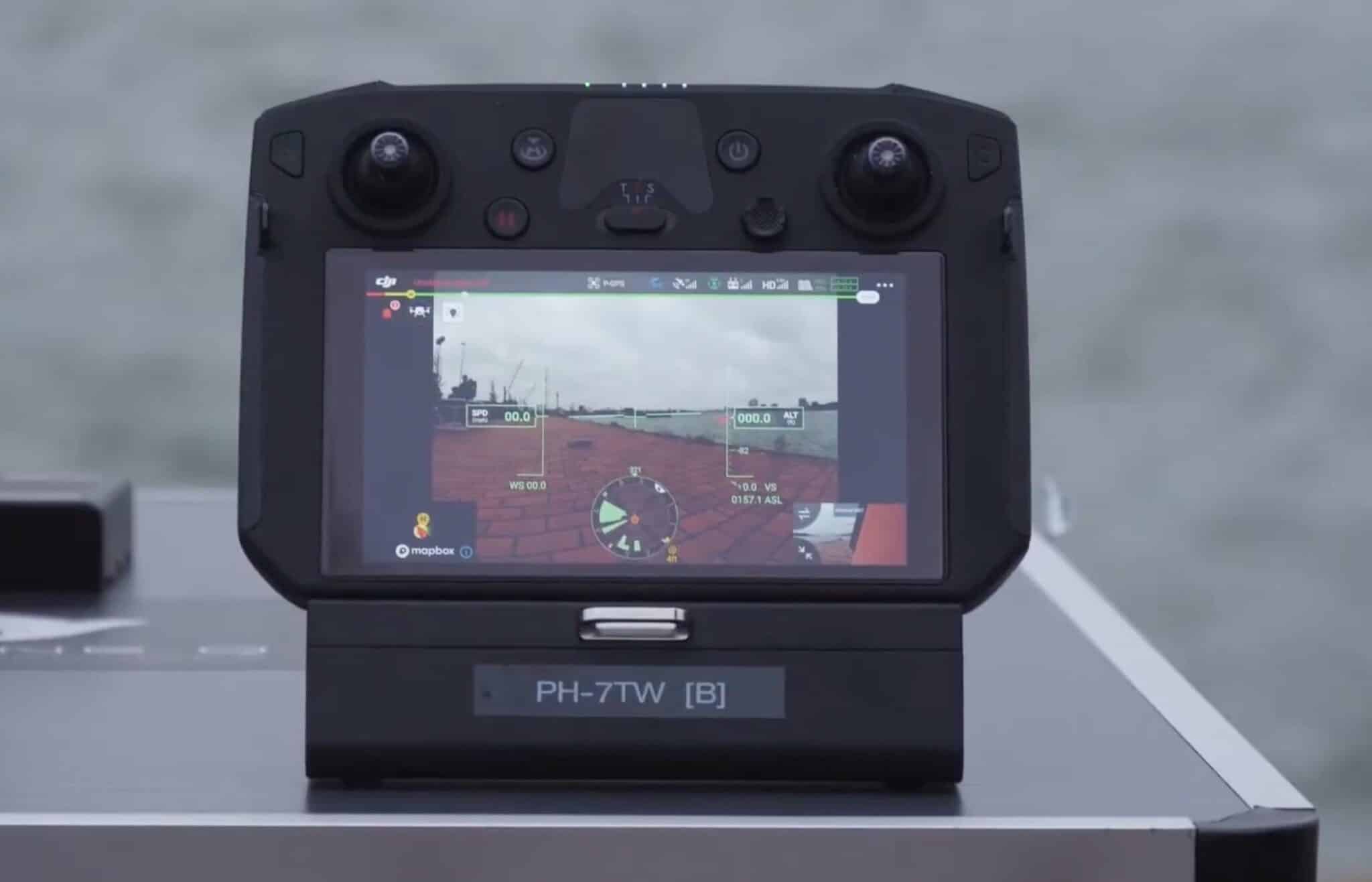 DJI Smart Controller on a table showing a flight view of the waterway.