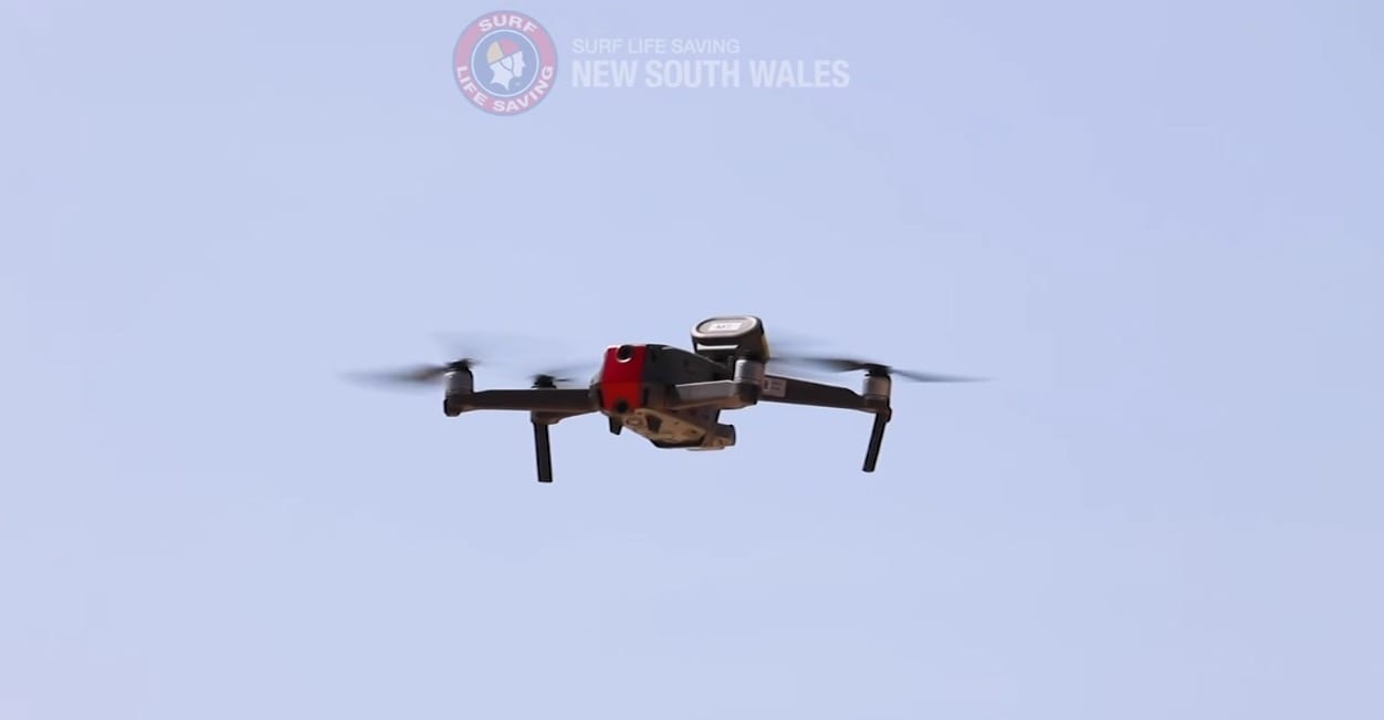 A DJI Mavic 2 Enterprise with loudspeaker module hovering over the surf.