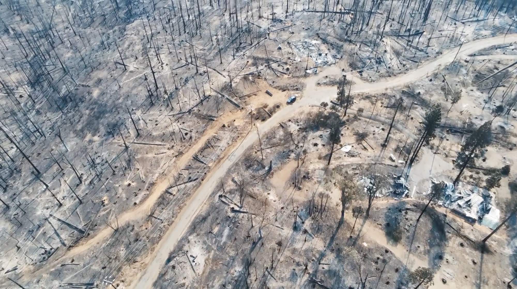 Aerial view of a burned hillside with destroyed homes after the CZU fire.