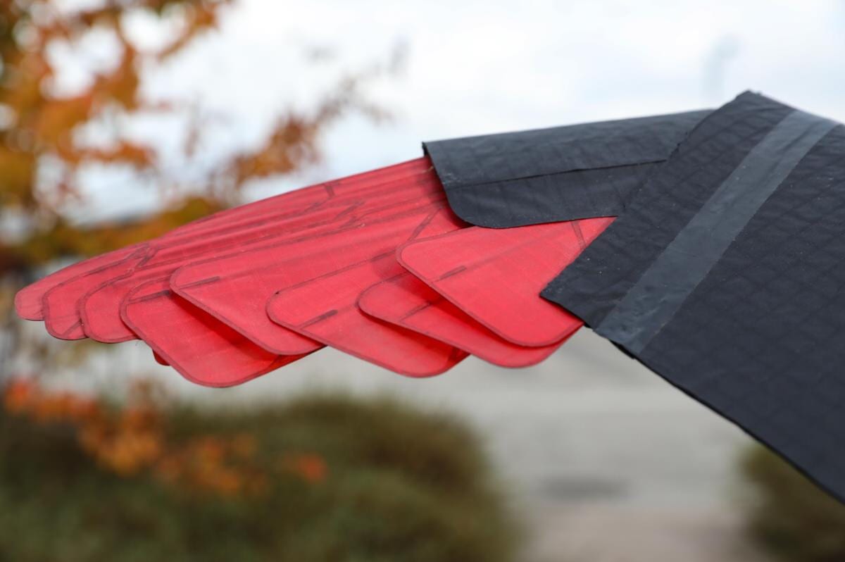 Close-up of the overlapping red artificial feathers that let the wing change shape.