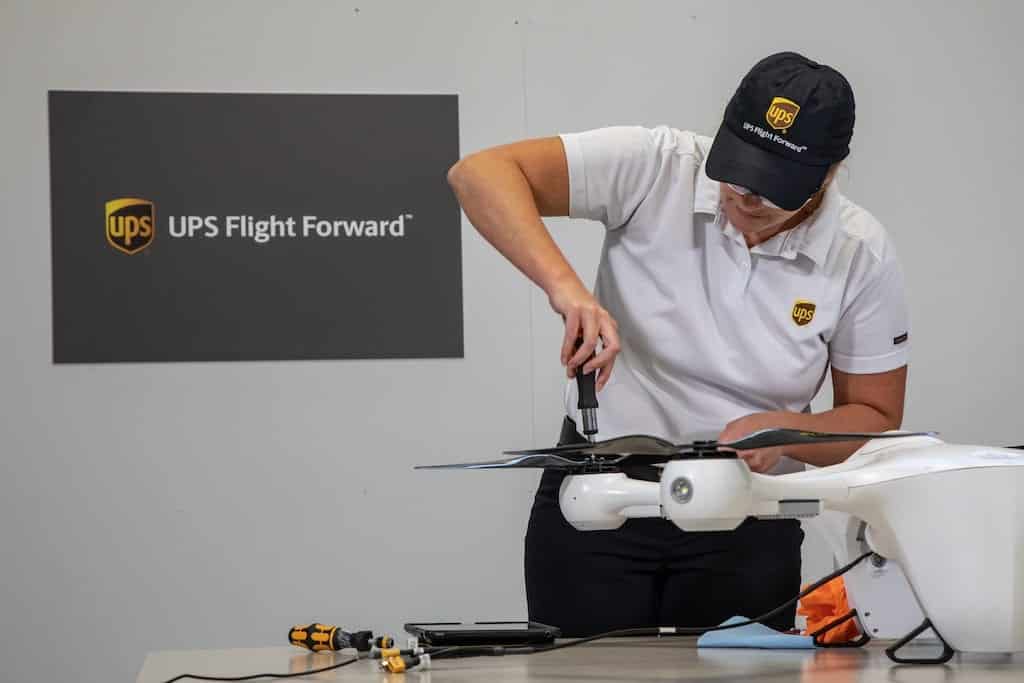 UPS Flight Forward technician assembling a delivery drone at a workbench.
