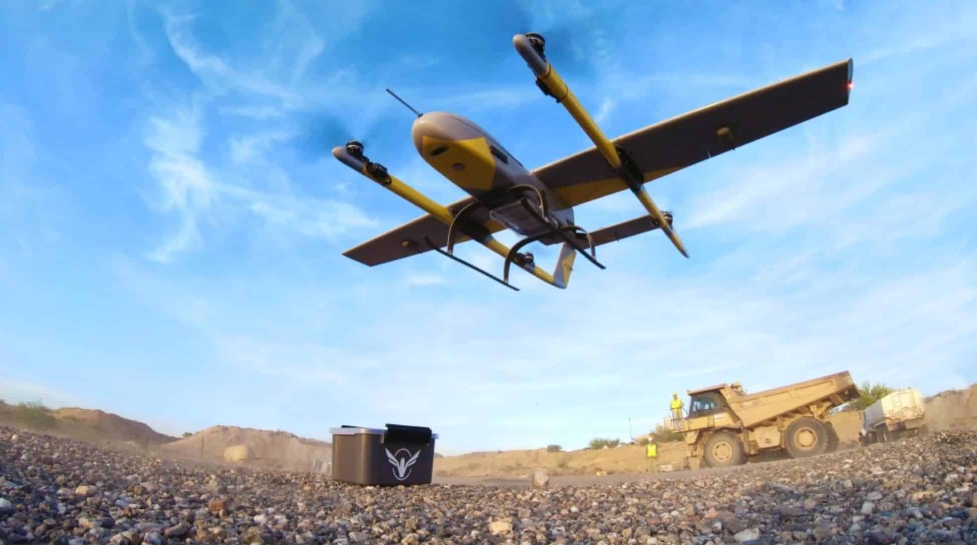 Volansi delivery drone climbing above a quarry with a haul truck below.