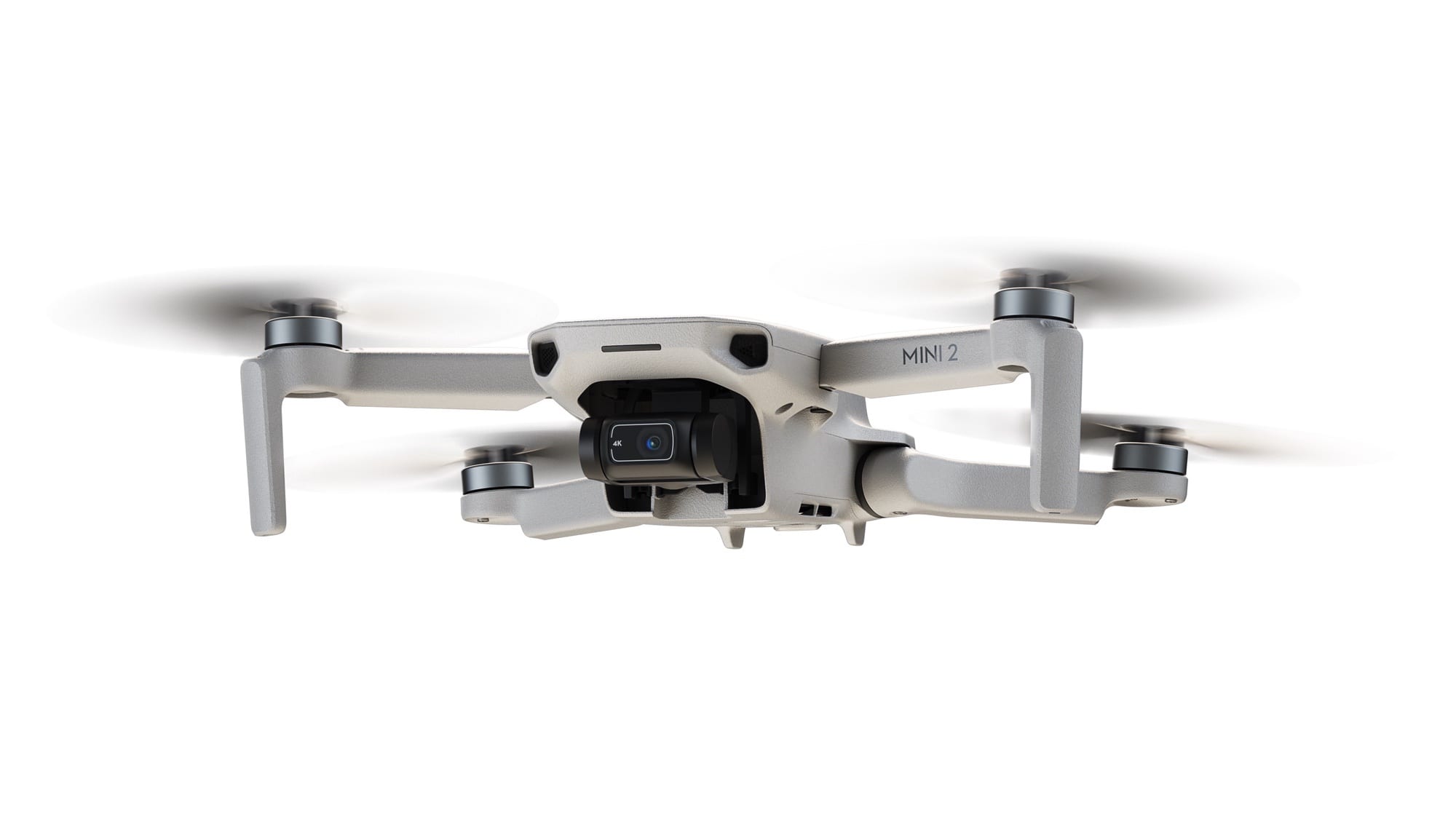 The DJI Mini 2 hovering with its three-axis gimbal camera visible.
