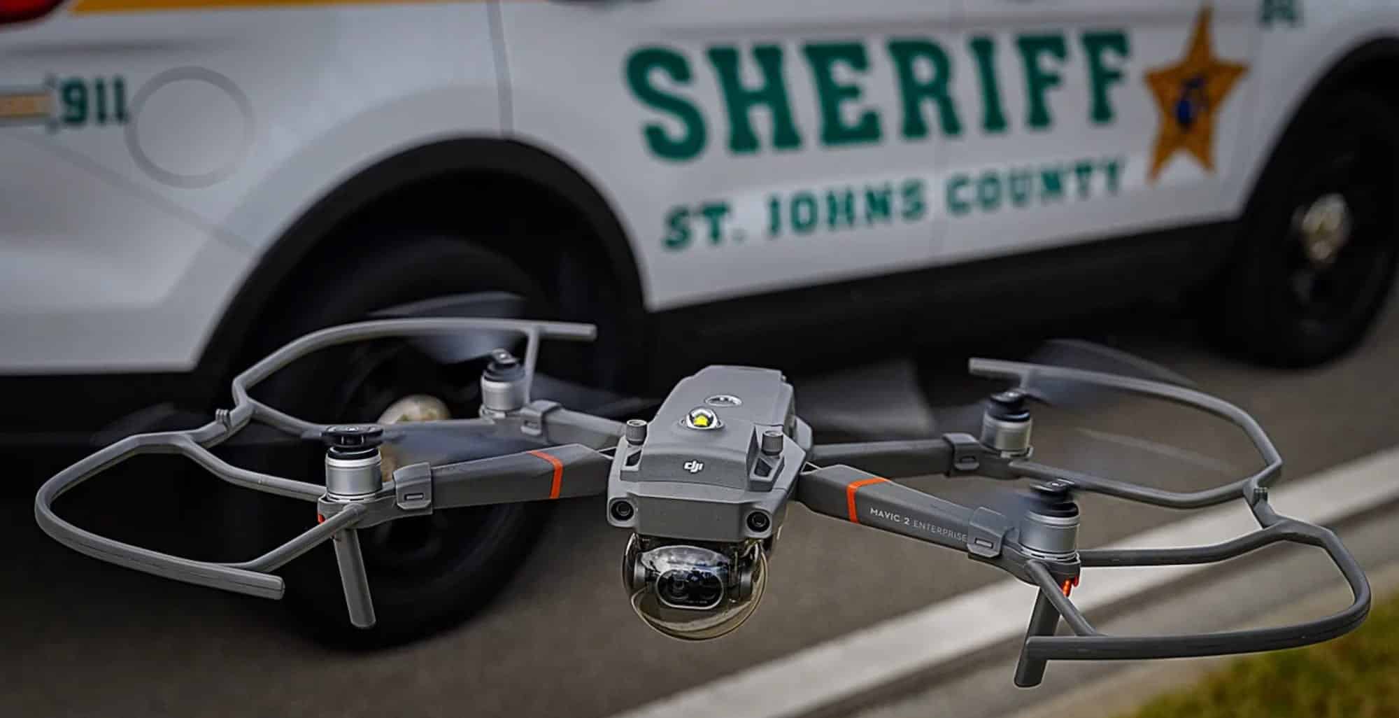 DJI Mavic 2 Enterprise with propeller guards parked before a St. Johns County Sheriff SUV.
