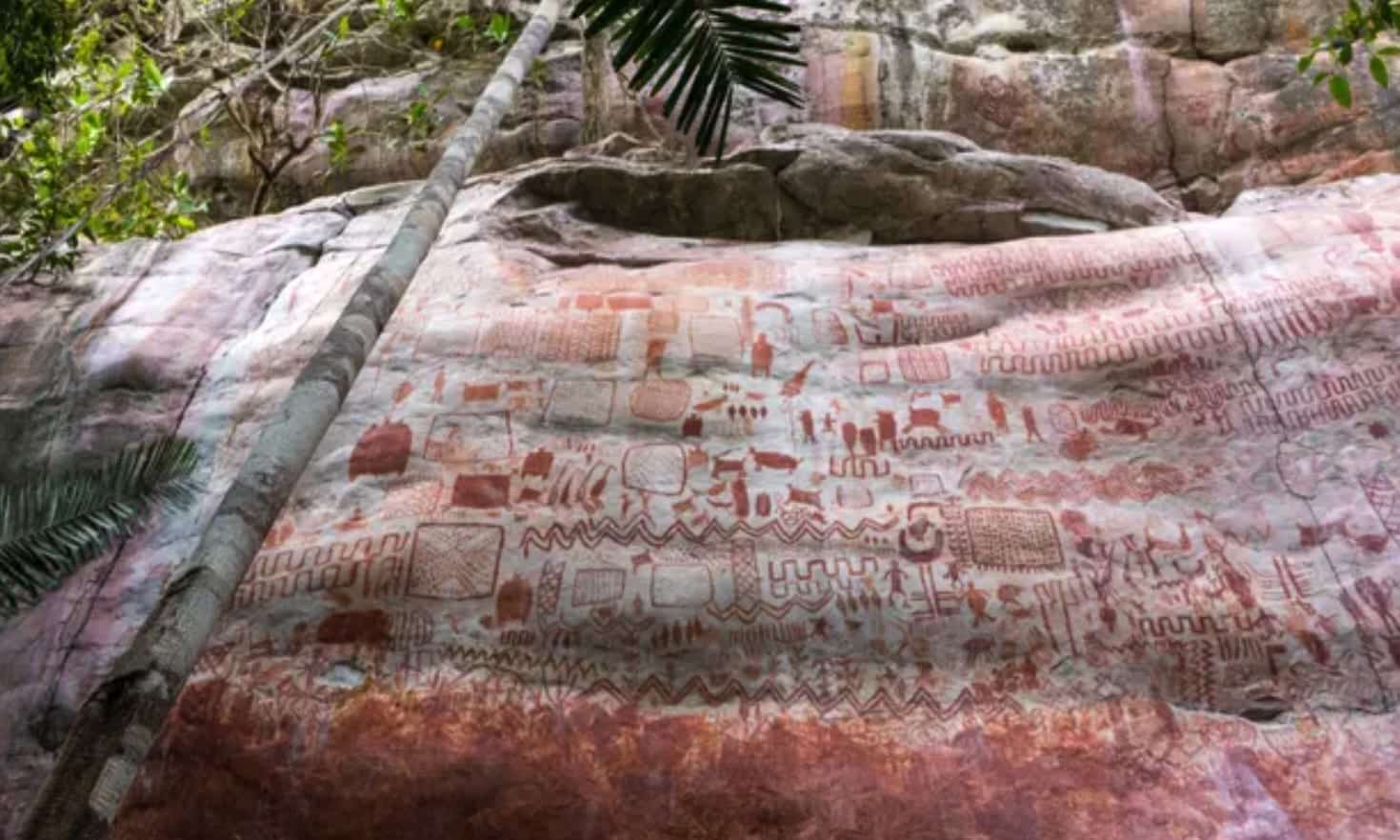 Cliff face covered with red prehistoric rock paintings in the Colombian Amazon.