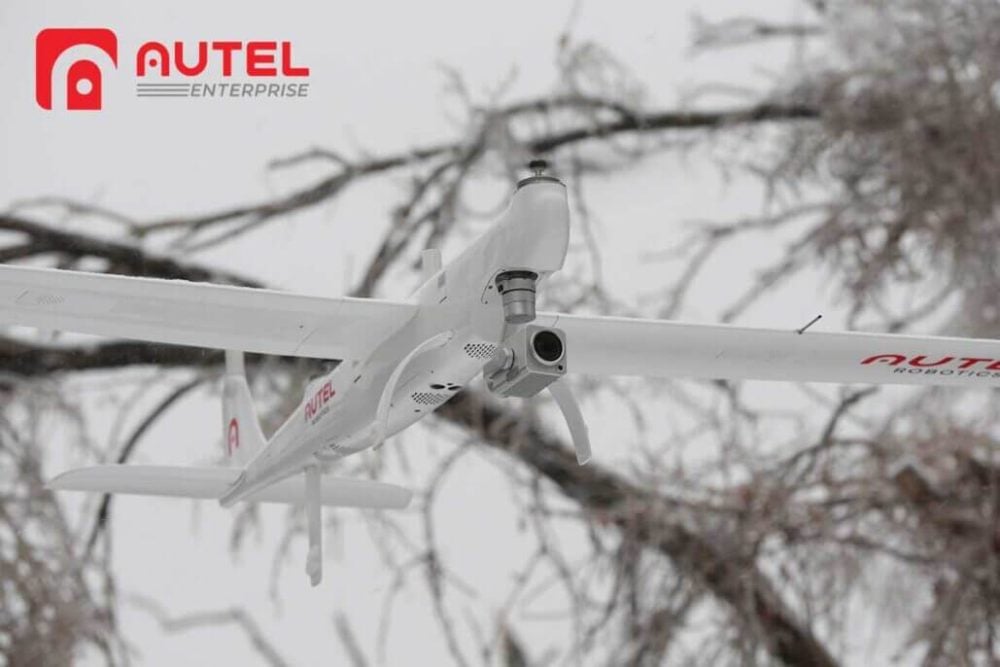 The white Autel Dragonfish VTOL drone framed by frost-covered branches.