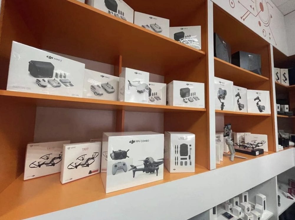 Retail shelves stocked with DJI product boxes including the FPV Combo.