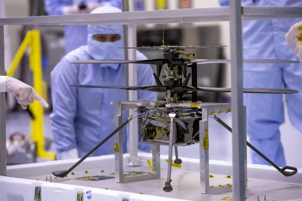 Technicians in cleanroom suits work on the Ingenuity Mars helicopter.