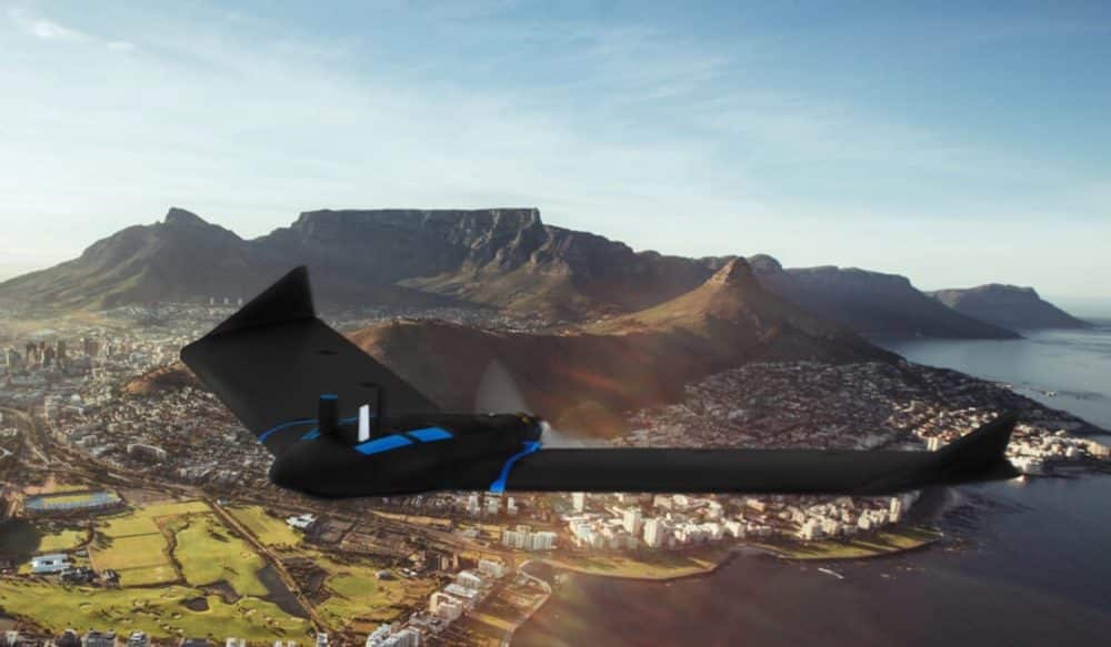 A black fixed-wing survey drone composited in flight above Cape Town and Table Mountain.