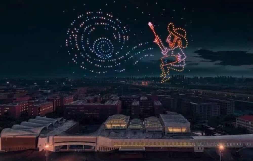 Drone light show forming a Van Gogh swirl and painter figure above a city.