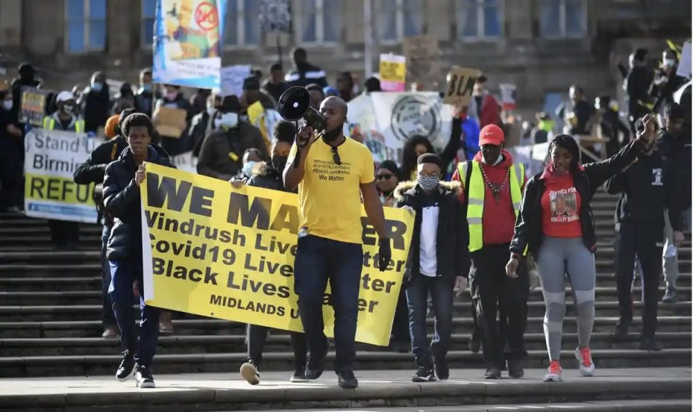 Protesters march down steps with banners at a Black Lives Matter demonstration.