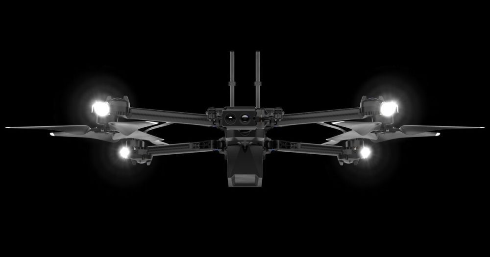 Skydio X2 reconnaissance drone shown head-on with its lights lit against black.