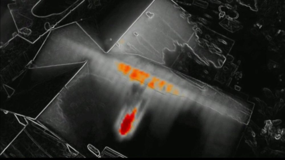 Thermal drone image of a house roof with orange and red hot spots.