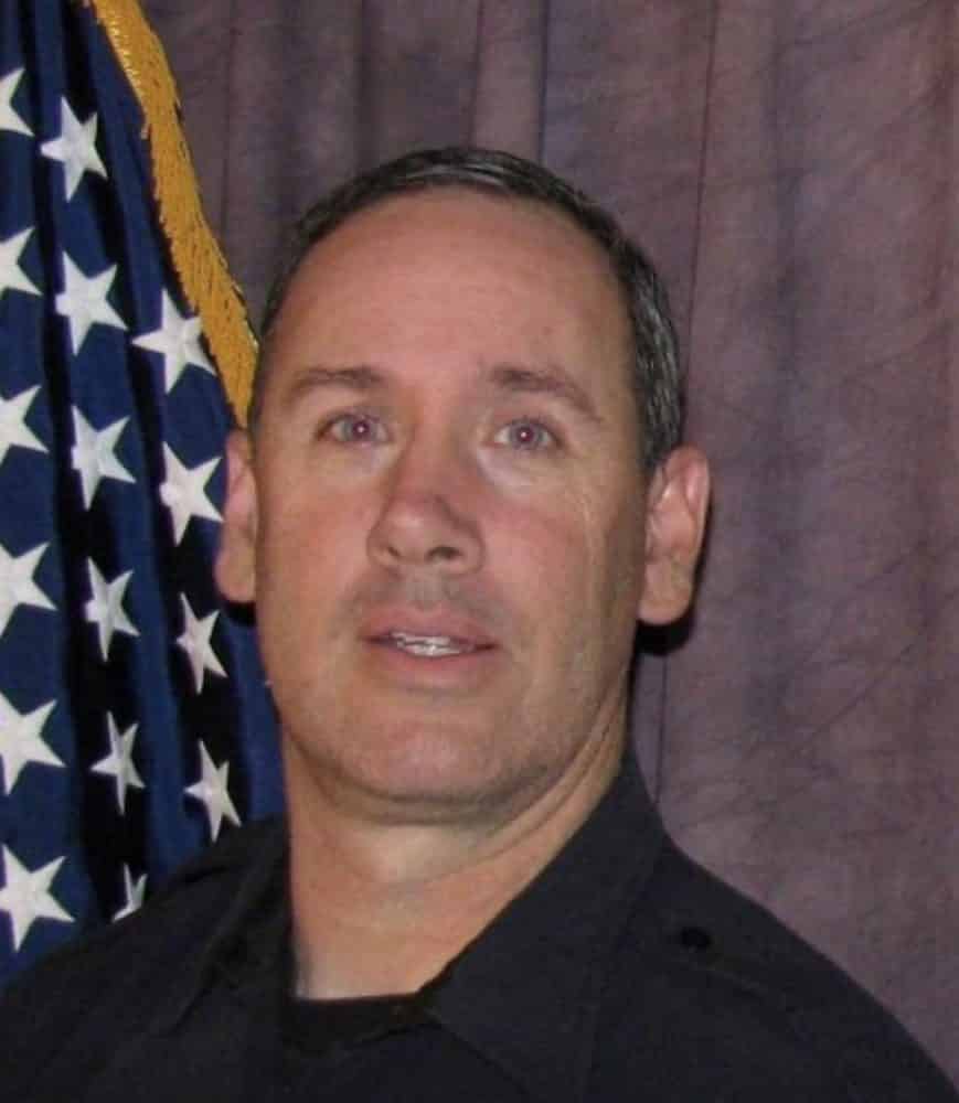 Portrait of the slain Colorado police officer in front of an American flag.