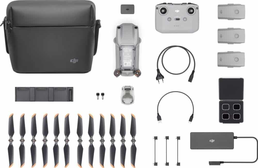 Flat lay of DJI Air 2S Fly More Combo contents: bag, batteries, propellers, and charger.
