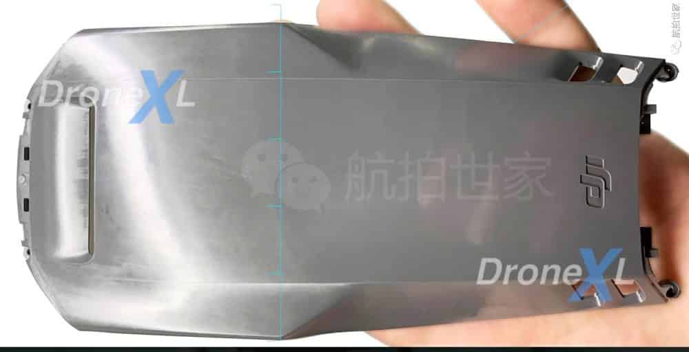 Hand holding an unpainted DJI Mavic 3 top shell with the DJI logo molded in.