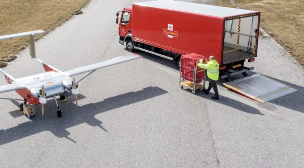 Windracers fixed-wing cargo drone parked beside a red Royal Mail lorry.