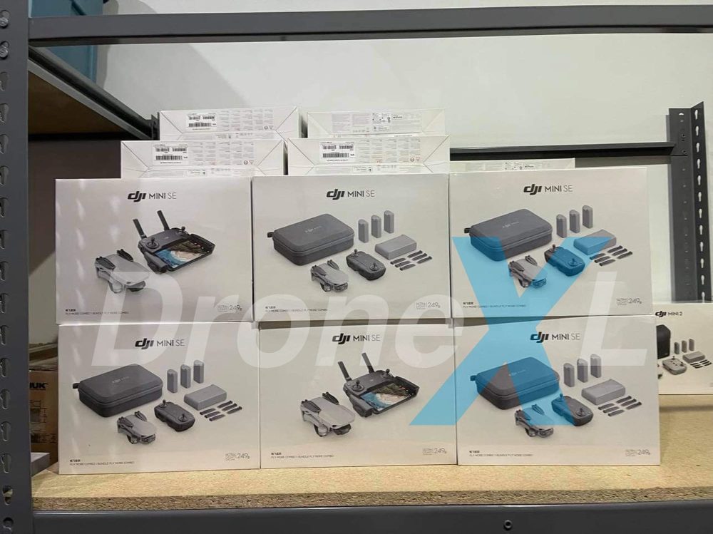 DJI Mini SE boxes stacked on a retail store shelf behind glass.