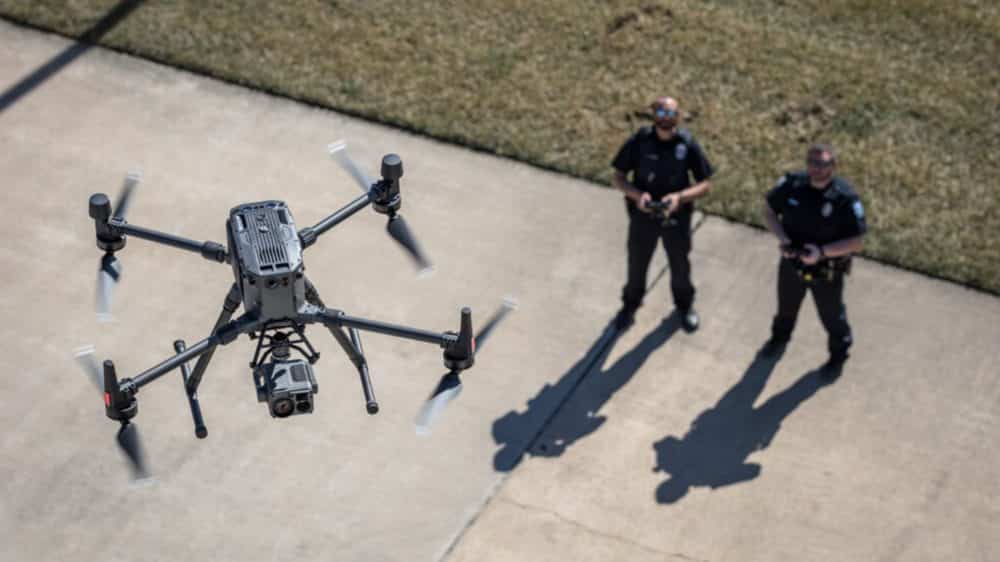 Drone hovering above two Vallejo officers standing on a driveway.