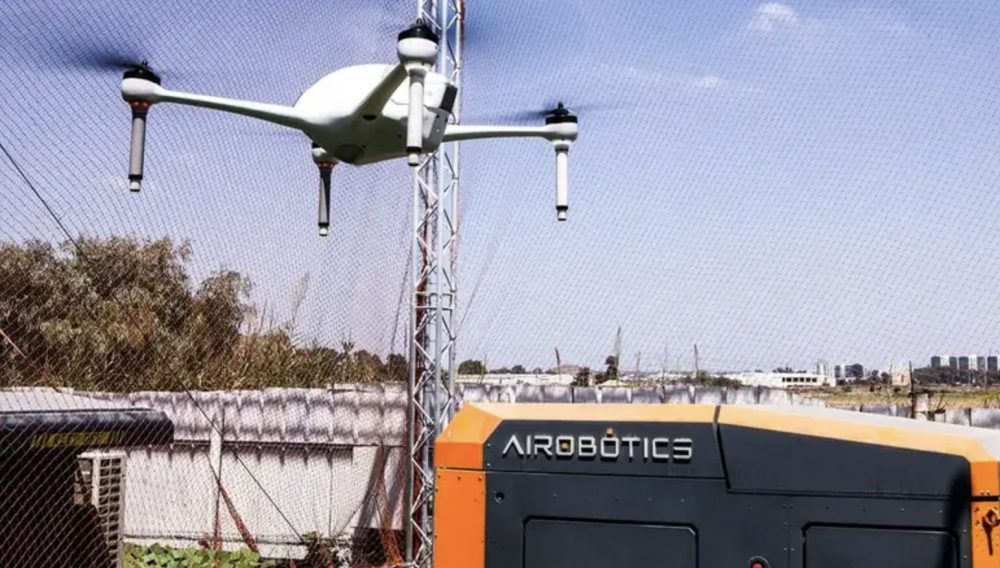White drone lifting off from an Airobotics drone-in-a-box station.