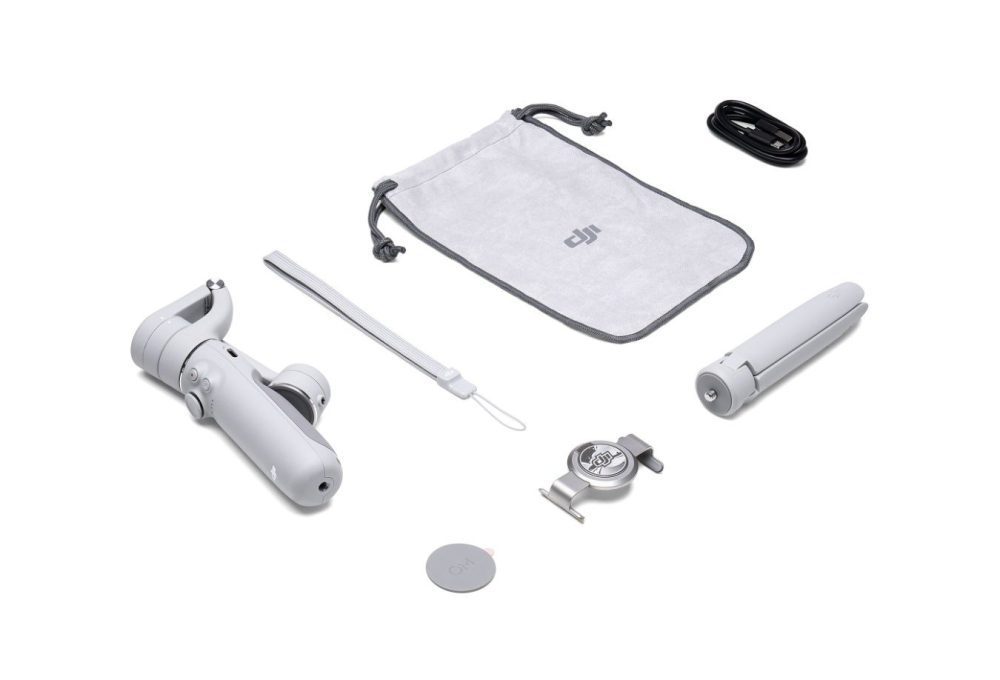 The DJI OM 5 folded flat beside its magnetic phone clamp.