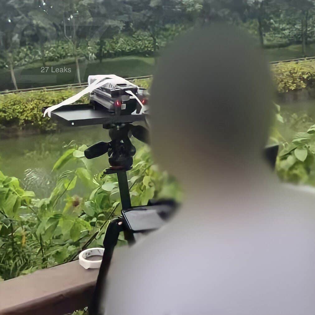 Leaked shot of a folded Mavic 3 taped to a tray beside a blurred tester.