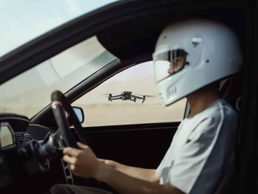 DJI Mavic 3 flying above a car drifting on tarmac.