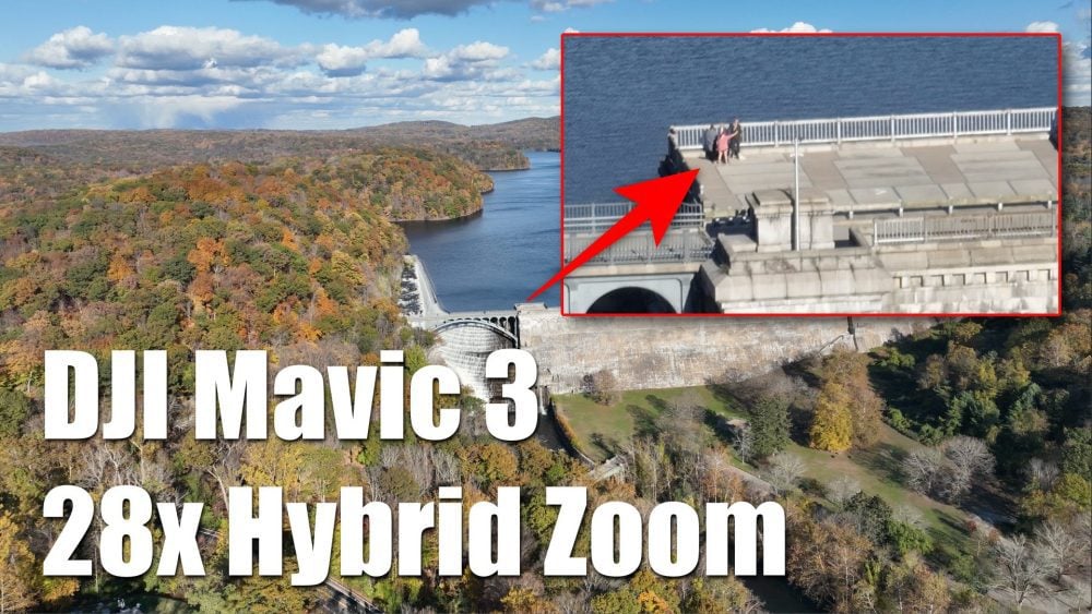 Aerial view of a dam in autumn with a zoom inset revealing people on it.