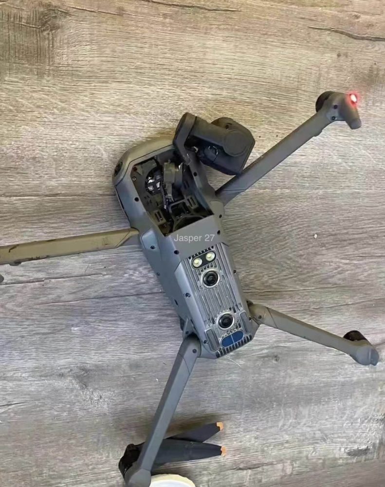Damaged DJI Mavic 3 on wooden decking with the gimbal torn from its nose.