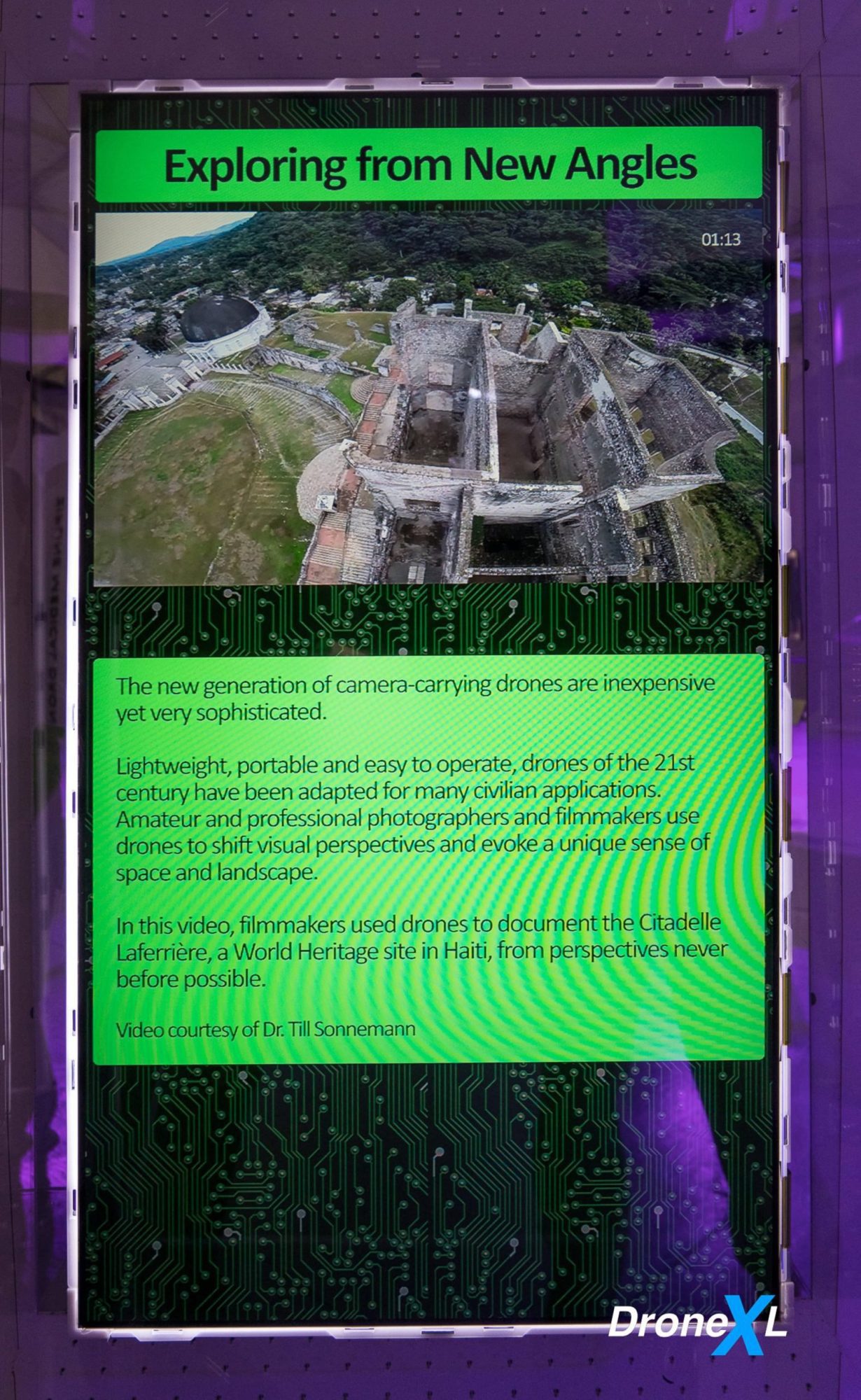 Exploring from new angles display featuring aerial footage of Haiti's Citadelle Laferrière.