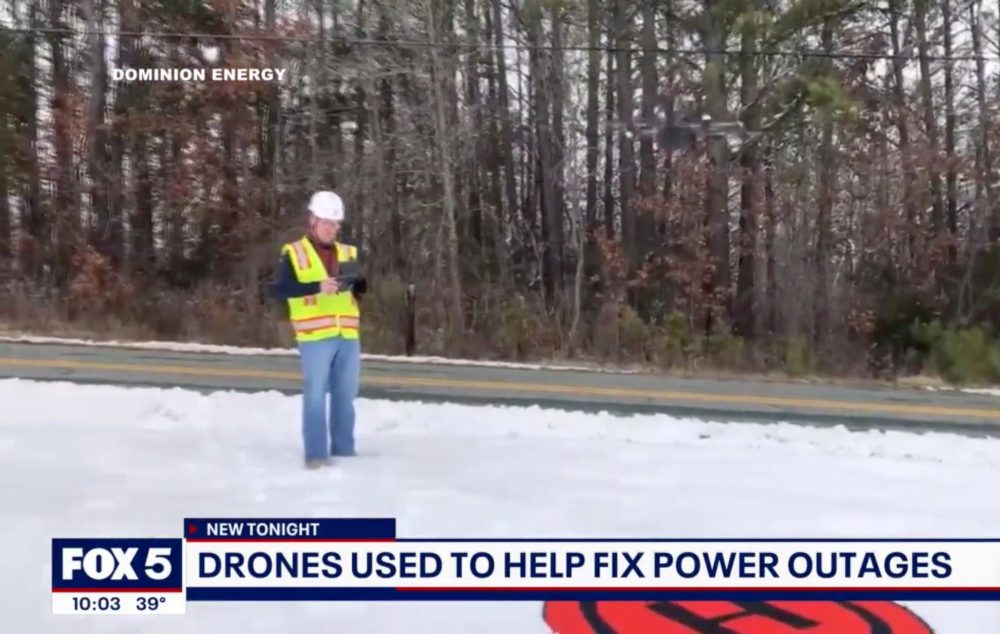 News frame of a Dominion Energy worker flying a drone on a snowy road.