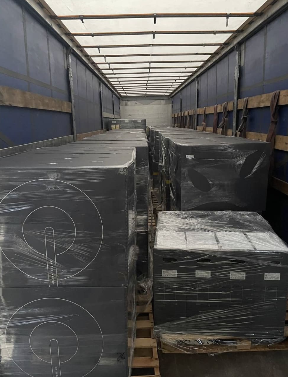 Shrink-wrapped Starlink terminal pallets loaded inside a delivery truck.