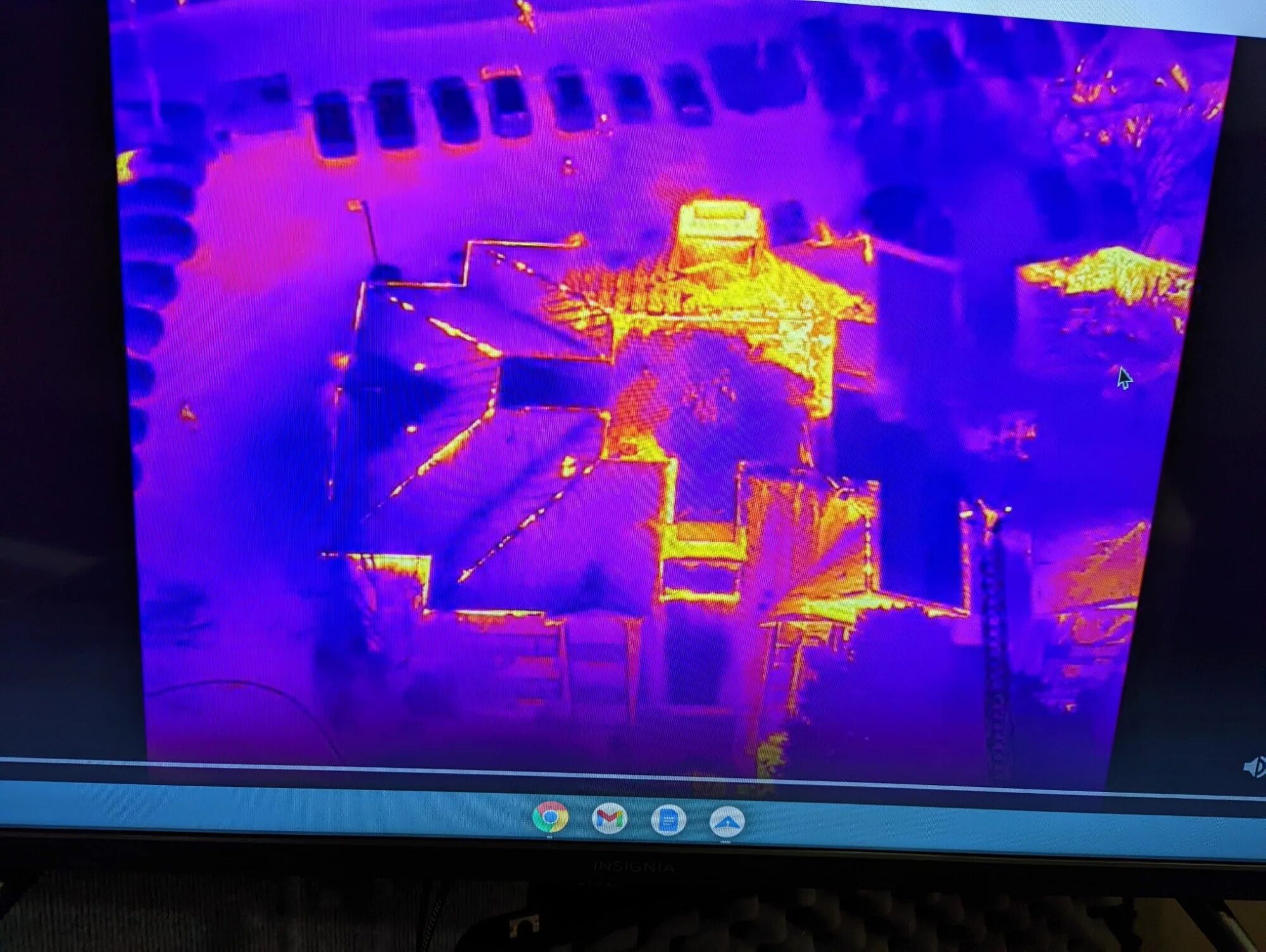 Laptop showing a thermal image of vehicles in purple and orange.