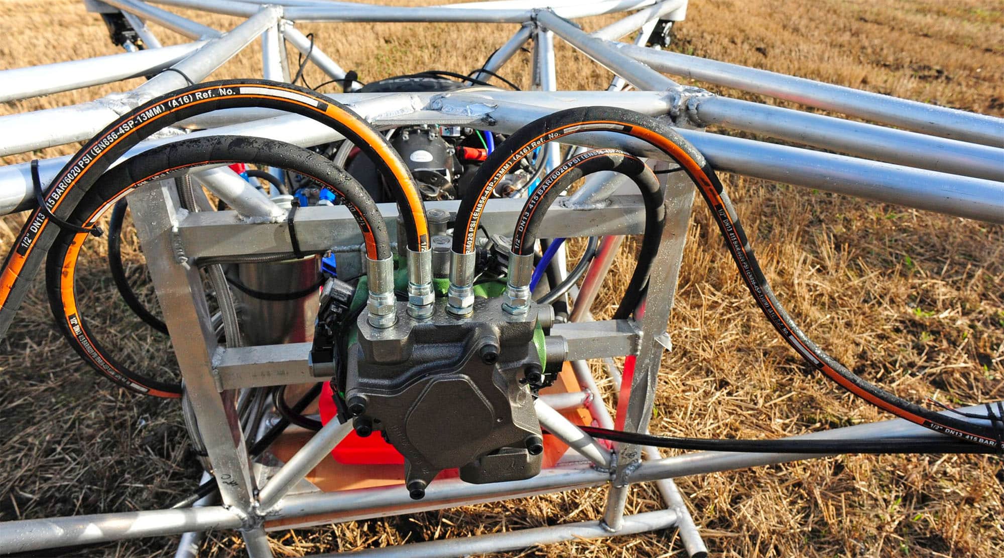 Close-up of the digital displacement pump and hydraulic hoses inside the tubular frame.
