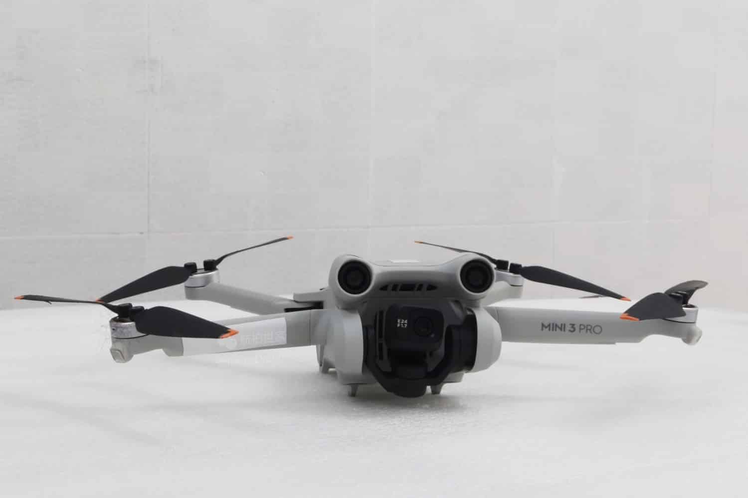 DJI Mini 3 Pro shown unfolded against a plain grey studio backdrop.