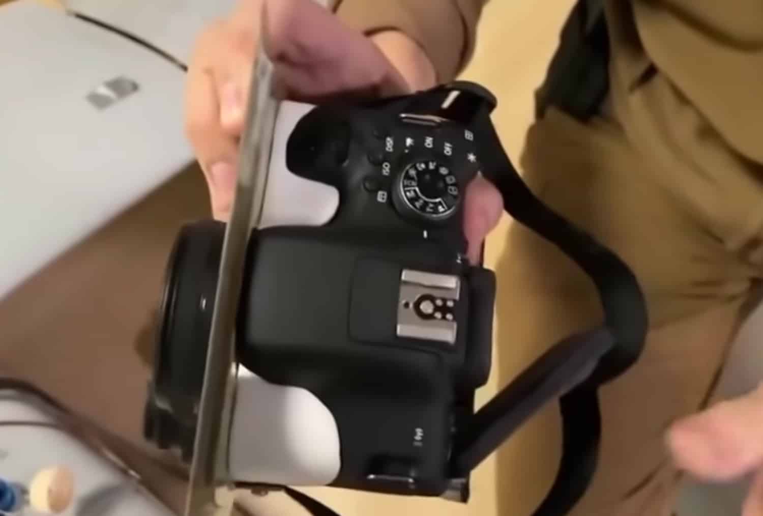 A soldier holds up the Canon DSLR pulled from the drone's camera bay.