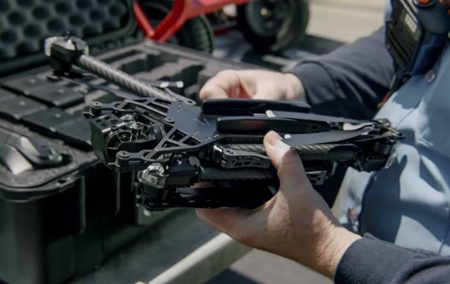 Hands lifting a folded Skydio airframe out of a padded transport case.