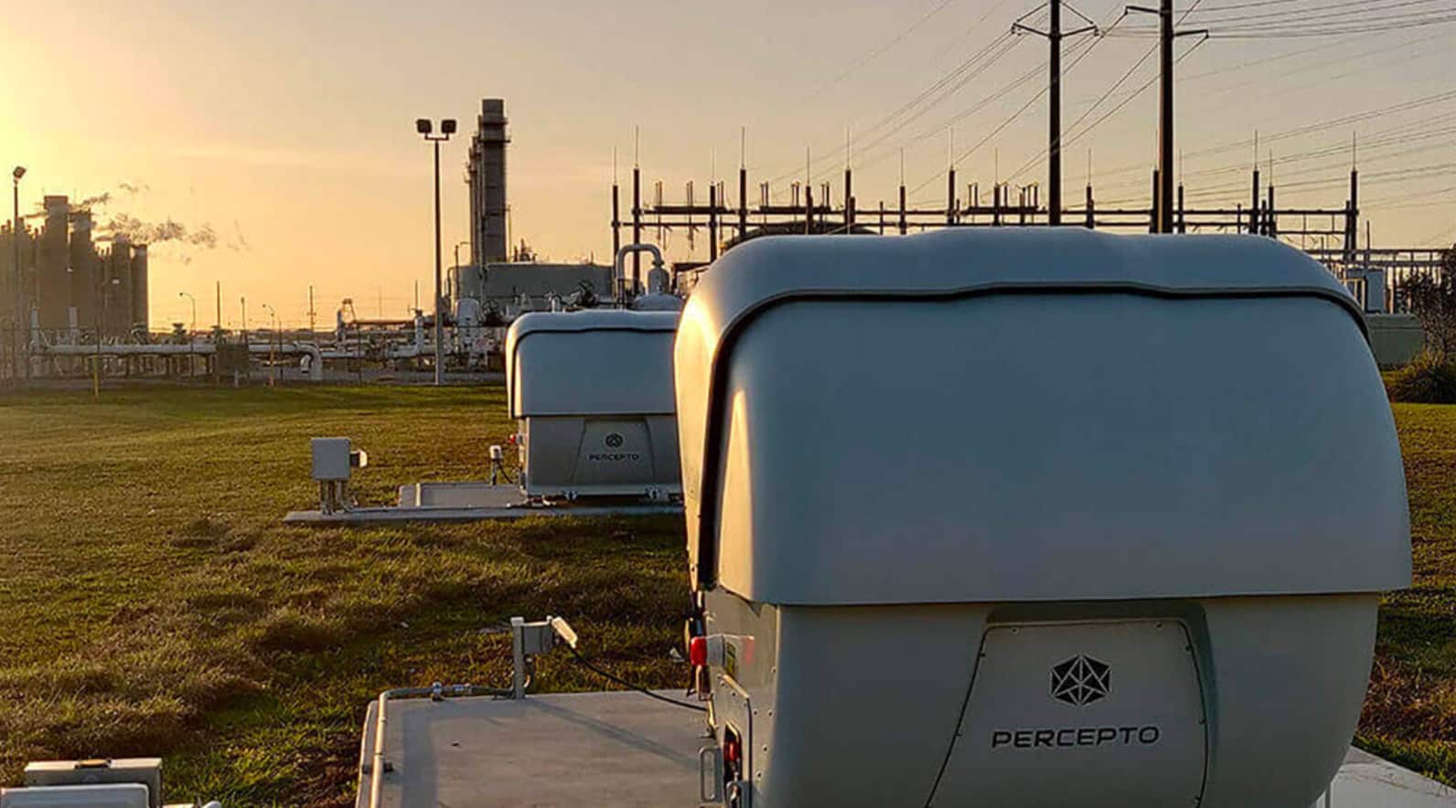 Percepto drone-in-a-box station beside a power substation at sunset.