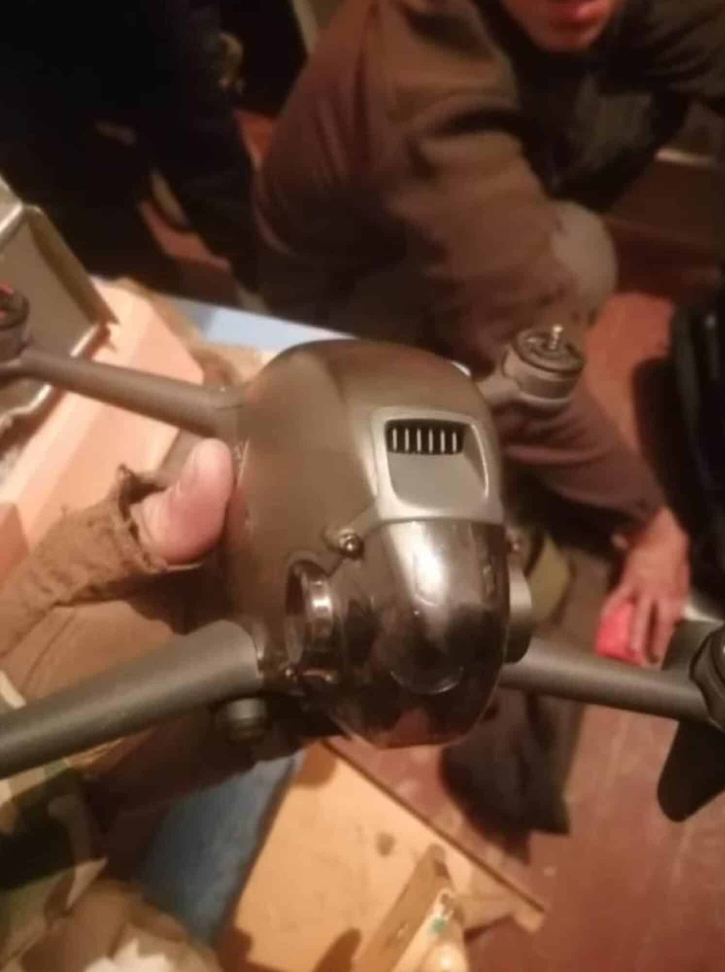 Blurry photo of soldiers holding a DJI FPV drone in their hands.