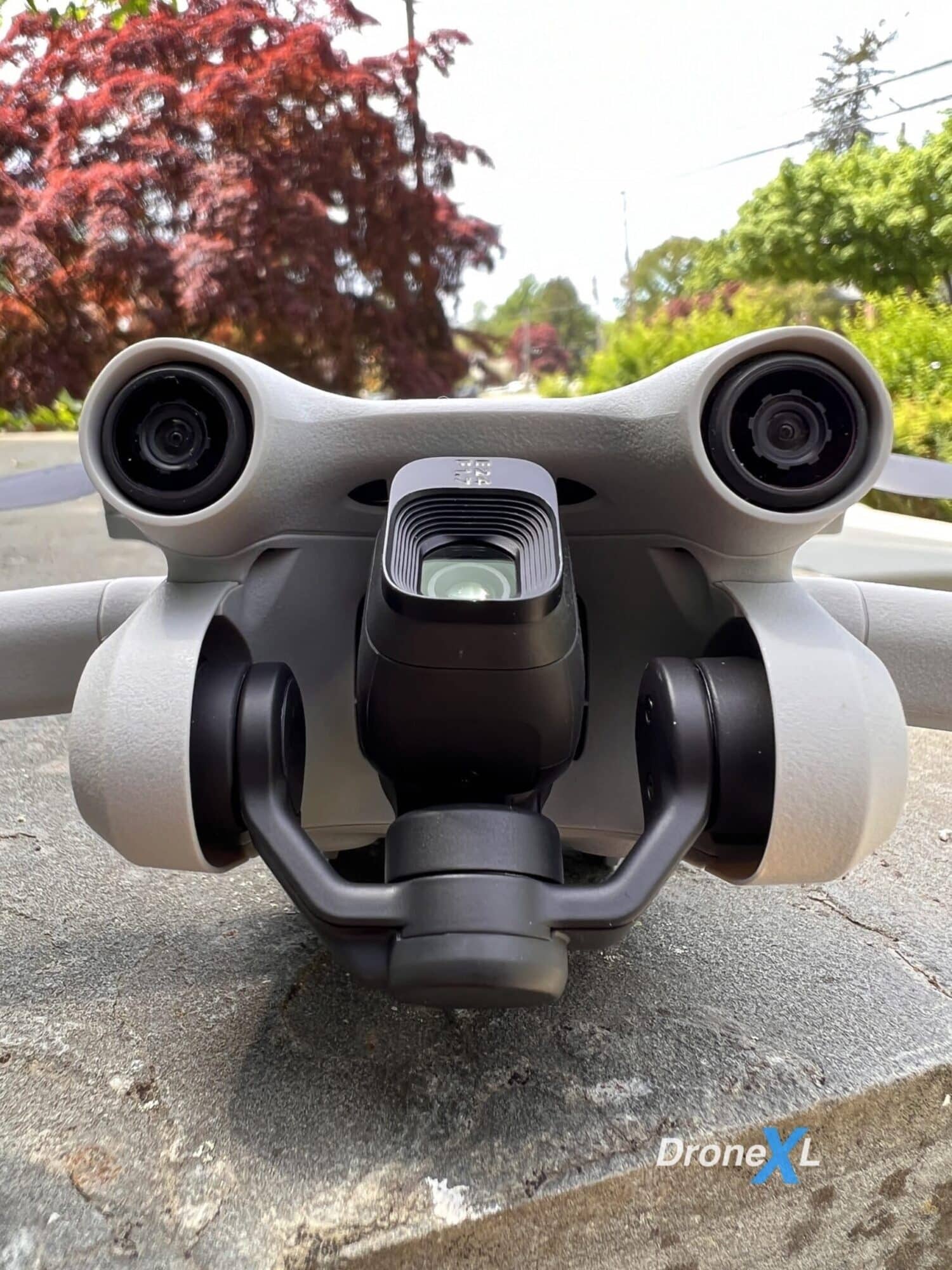 DJI Mini 3 Pro seen head-on with its camera tilted sharply upward.