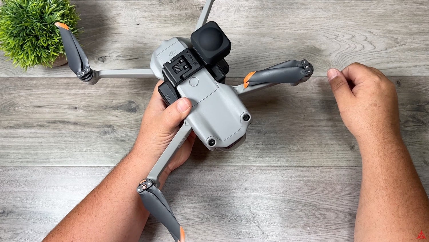 Hands fitting the Insta360 Sphere onto a DJI Mavic Air 2 body.