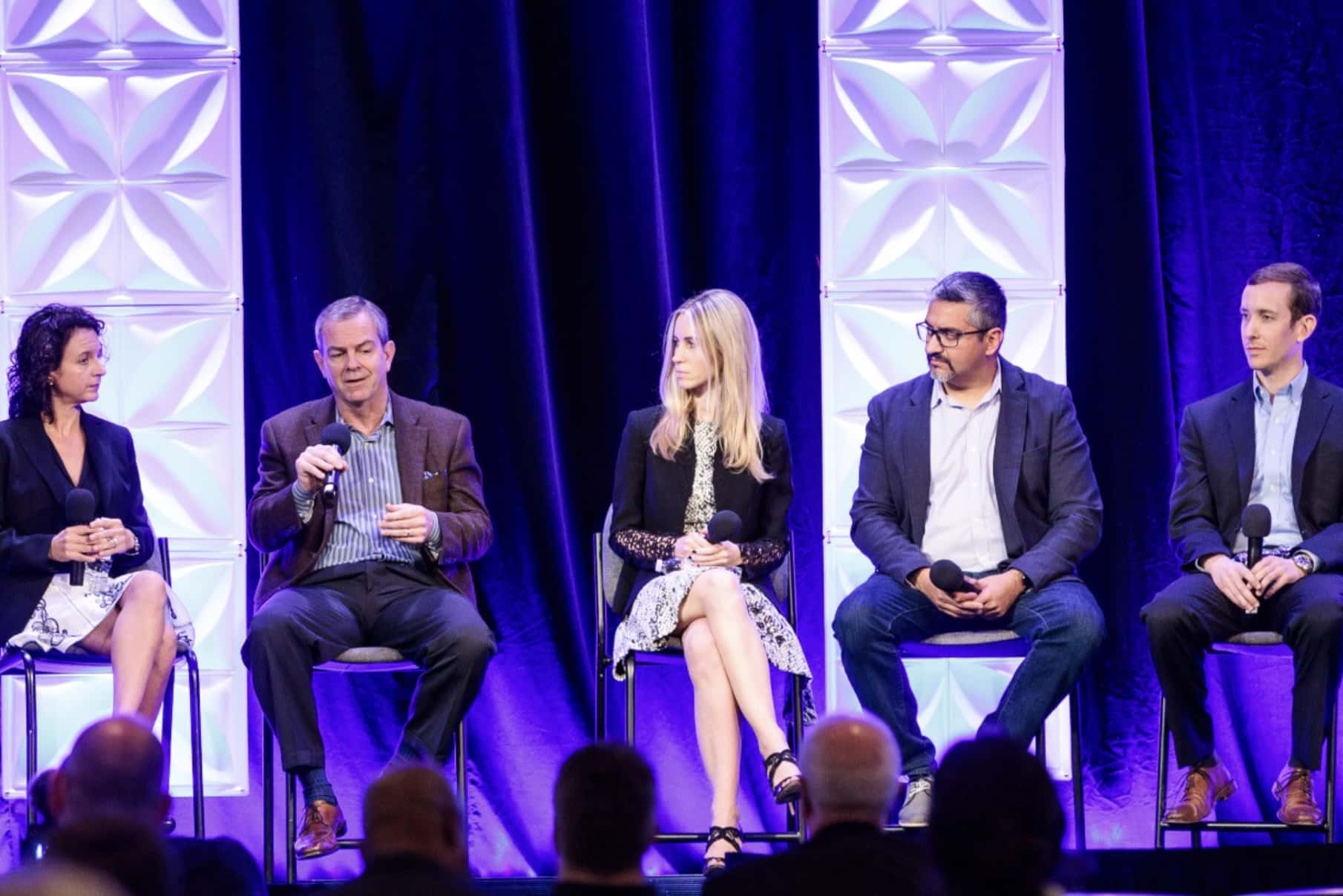 Five panelists seated on stage during a DJI AirWorks conference session.